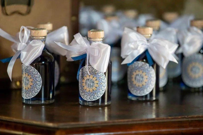 Primo piano di boccette di vetro blu con etichette decorate con motivi geometrici e fiocco bianco sul collo della boccetta.