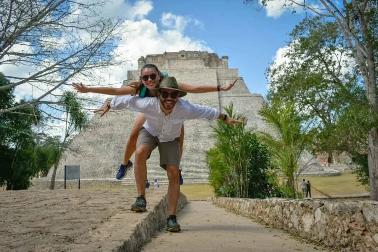 Uomo e donna in abiti sportivi sul sentiero di cemento durante il giorno con sullo sfondo una piramide azteca